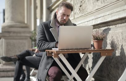 Vyras naudojasi kompiuteriu lauko kavinėje. Andrea Piacquadio nuotr. / Pexels.com