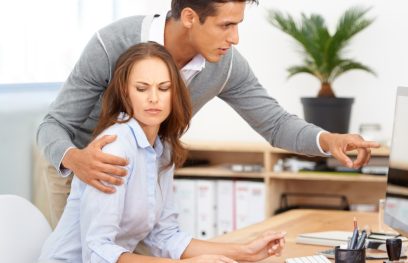 Vyras nepageidaujamas apkabino moterį per pečius darbe. Istockphoto.com nuotr.