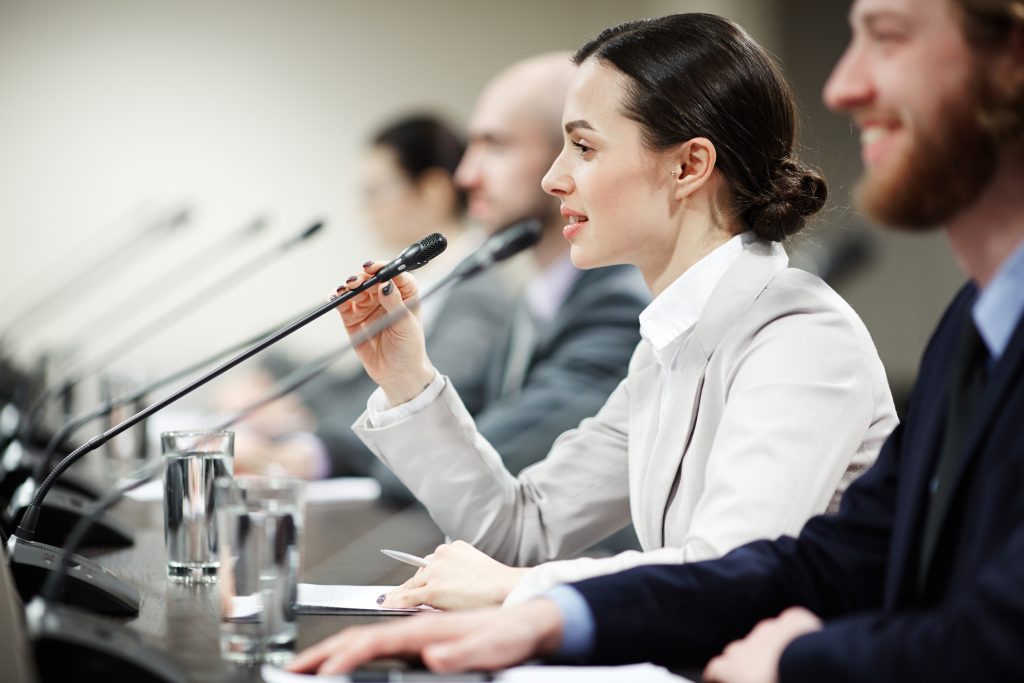 Politikė prie mikrofono. iStock.com/Shironosov nuotr.