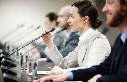 Politikė prie mikrofono. iStock.com/Shironosov nuotr.