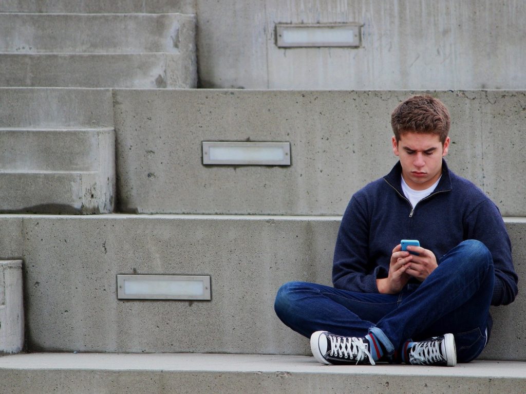 Vaikinas rašo SMS žinutę. Pixabay.com nuotr.