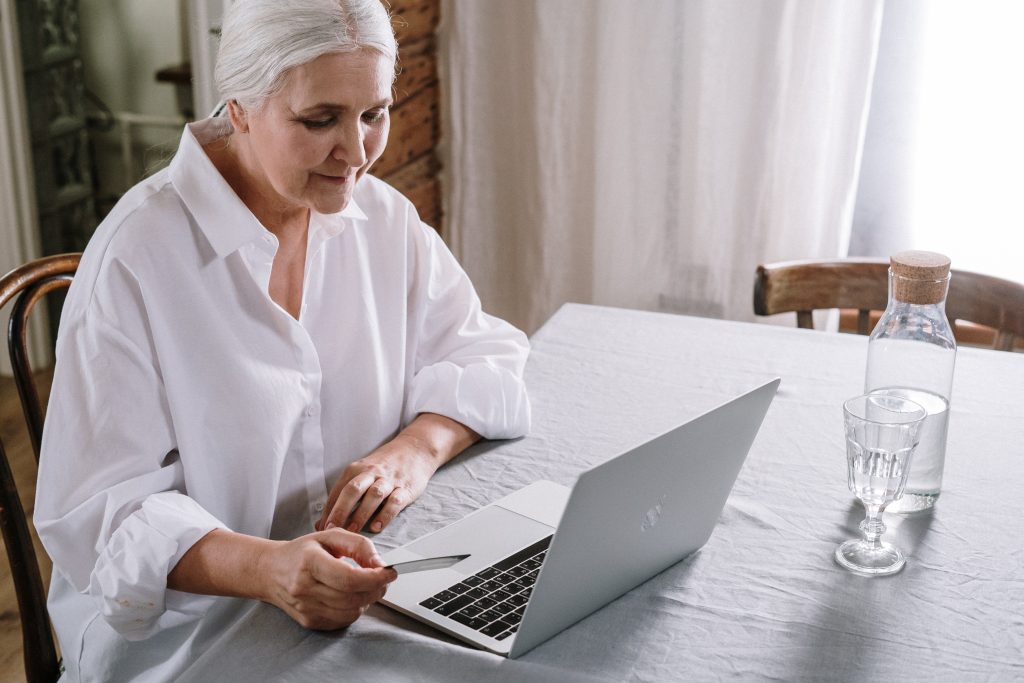 Vyresnio amžiaus moteris naudojasi kompiuteriu