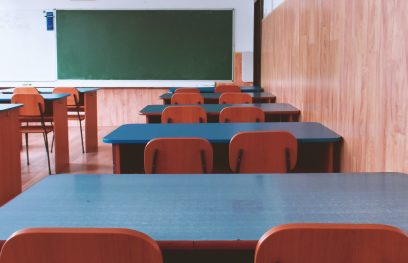 Tušti mokyklos suolai ir kėdės klasėje